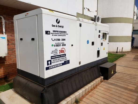 Grupo gerador carenado e silenciado instalado ao tempo, com identificação da Gen & Energy