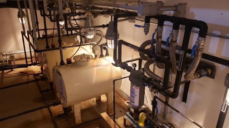 Conjunto de reservatórios metálicos aéreos instalados em sala de alvenaria